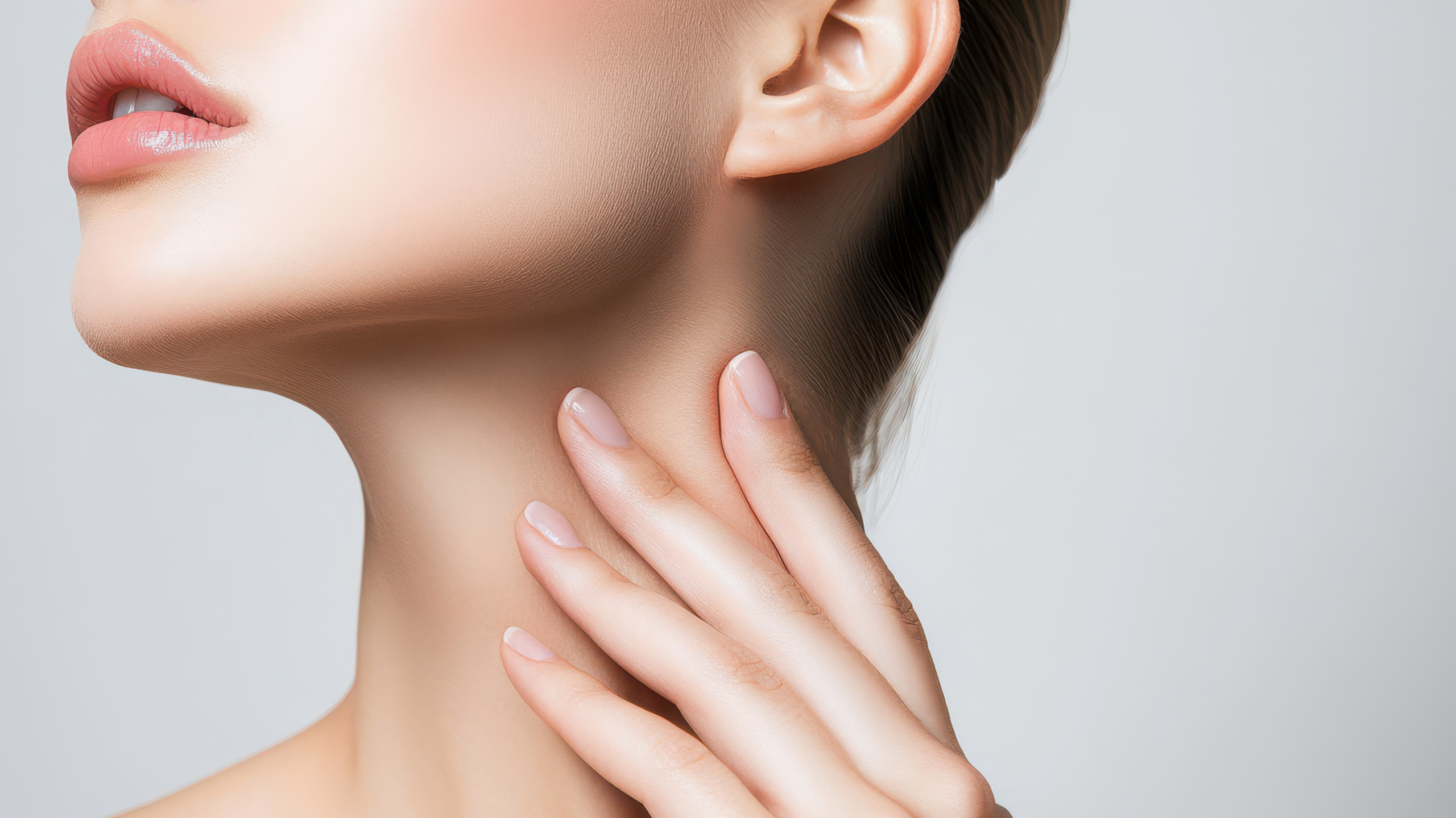 A woman touching her neck, representing early signs like skin tags around your neck.