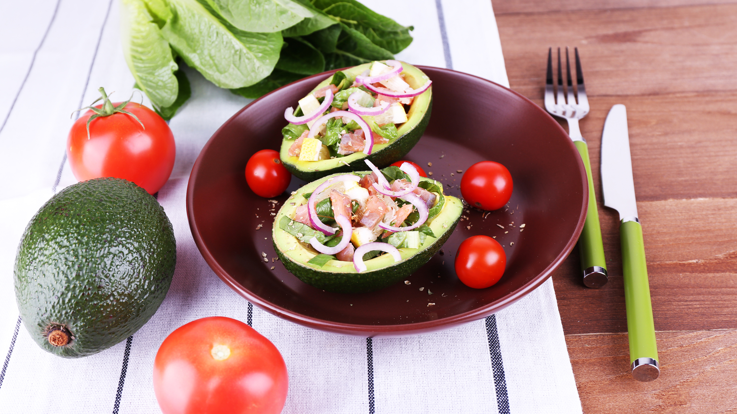 Avocado halves filled with tuna salad, cucumber, and herbs, shown as a quick high‑protein meal.